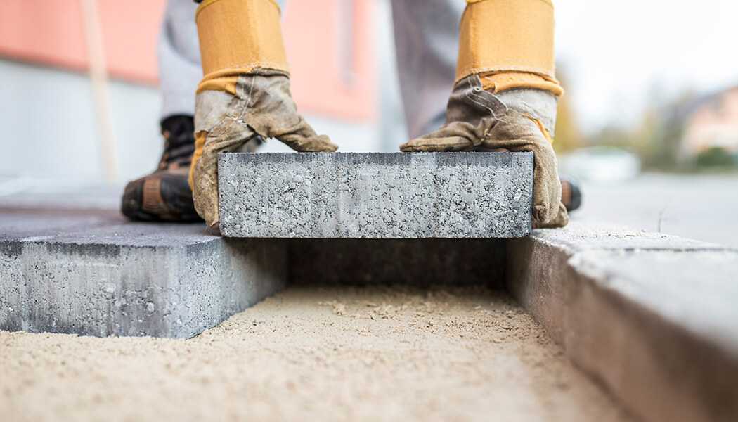 Foundation repair employee installing stones.
