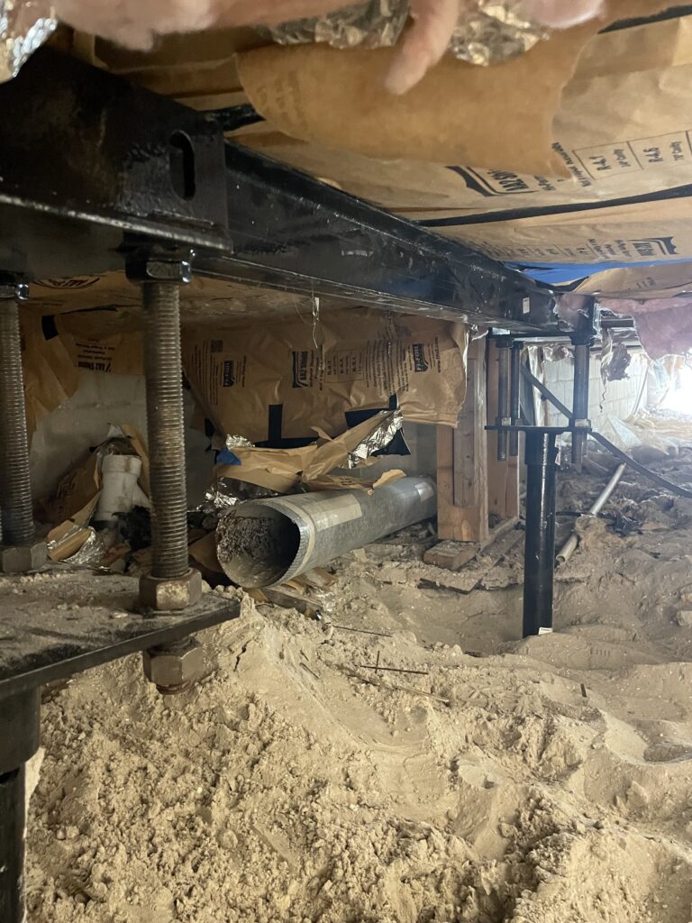 Supplementary metal i-beams supported by Florida Ram Jack’s engineered helical piles system used to repair the damaged crawl space